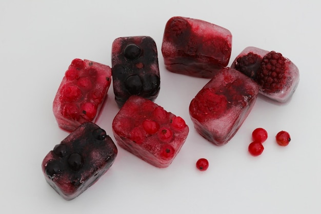 A group of ice cubes with red berries on the top.