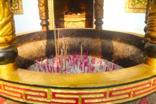 Group of Incenses Burning in a Golden Burner in front of Chinese Buddhist Shrine