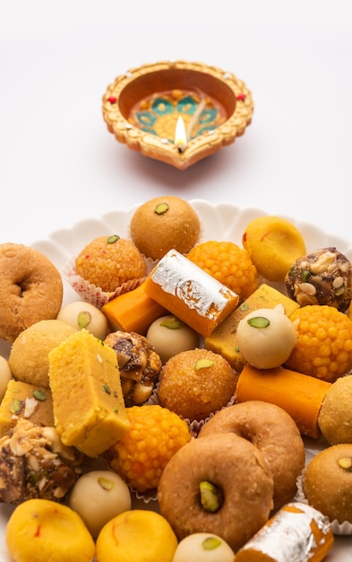 Group of Indian assorted sweets or mithai with diya