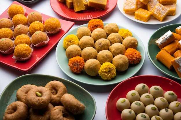 Photo group of indian assorted sweets or mithai with diya