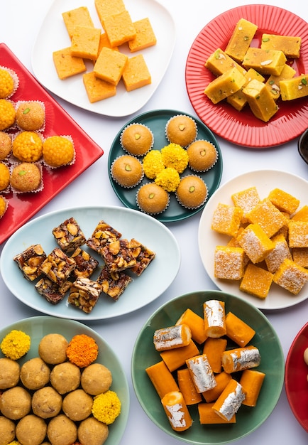 Photo group of indian assorted sweets or mithai with diya