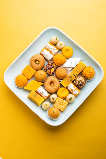 Group of Indian assorted sweets or mithai with diya