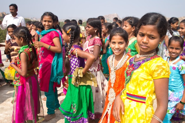 ハンピの古代の町、インドで茶色の学校の制服を着ているインドの学校の子供たちのグループ