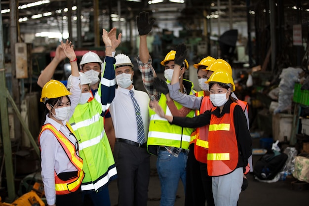 group of industry teamwork member doing hand raise up and cheerful as unity team.