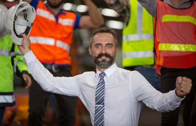 Gruppo di membri del lavoro di squadra del settore facendo alzare la mano e allegri come squadra di unità.