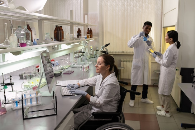 Group of intercultural scientists in whitecoats and gloves working in laboratory