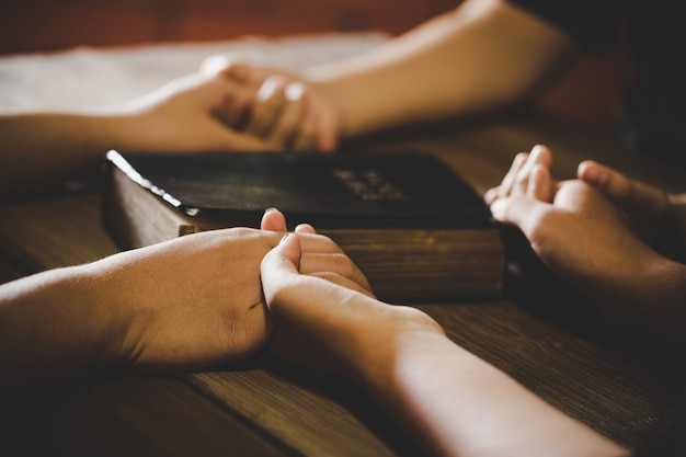 Group of interlocked fingers praying together