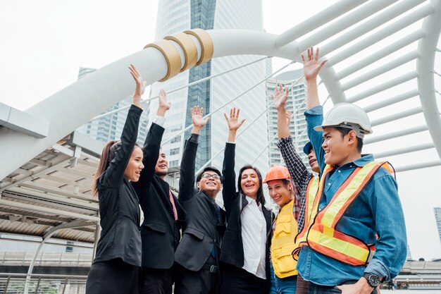 Group of international business and engineering partnership with hand raised up celebration of successful