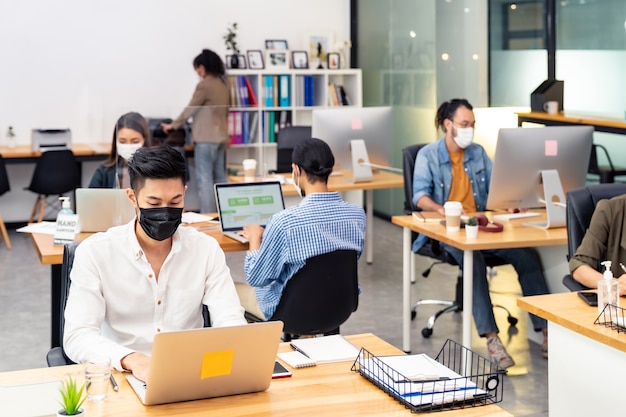 인종 간 비즈니스 작업자 팀 그룹은 새로운 일반 사무실에서 얼굴 보호 마스크를 착용합니다.