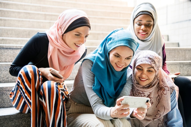 スマートフォンを見ているイスラム女性のグループ