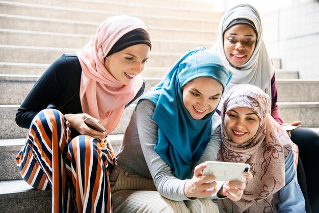 group of islamic women looking at smartphone