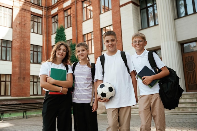 Group of kids are near the school together pupils