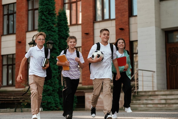 Group of kids are near the school together pupils