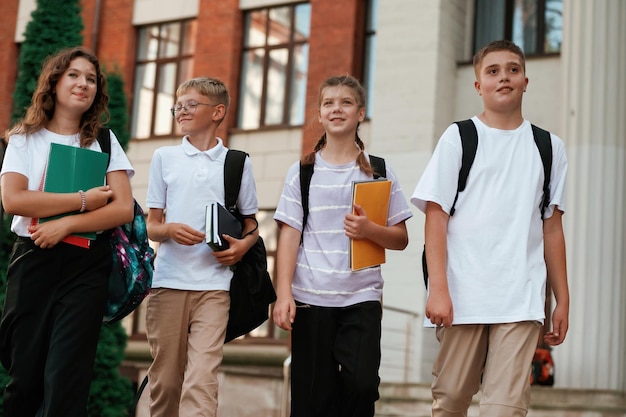 Group of kids are near the school together pupils
