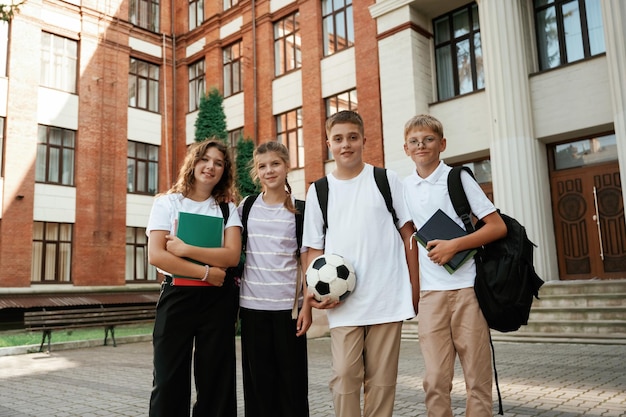 Group of kids are near the school together pupils