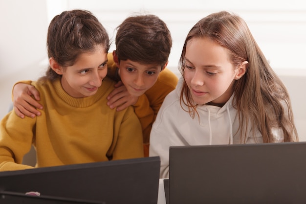 Gruppo di ragazzi in chat mentre si lavora su un computer insieme