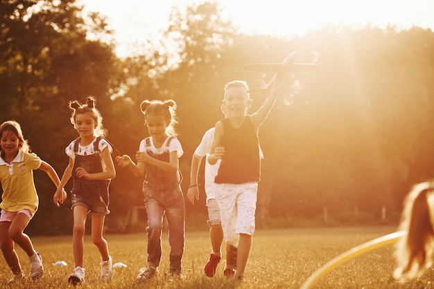 Group of kids have active weekend in the field. illuminated by beautiful sunlight.