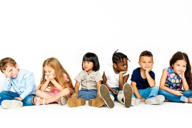 Foto gruppo di bambini in studio sparare e seduti insieme