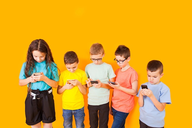 Gruppo di bambini che utilizzano il telefono cellulare digitale