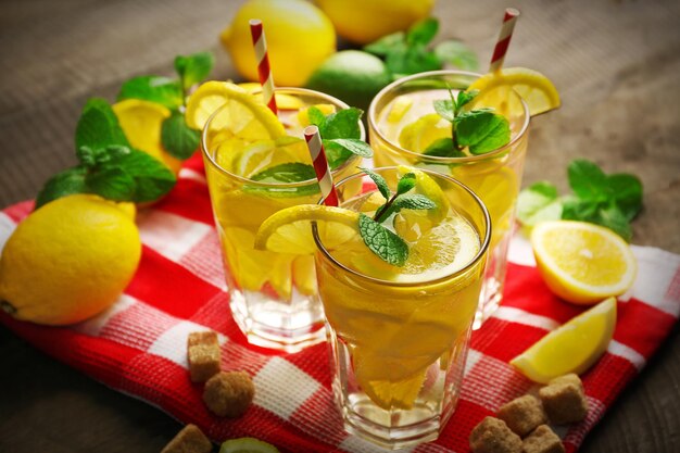 Group of lemonades with lemons and mint on cloth closeup