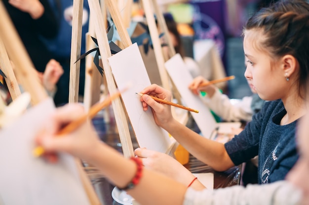 Group lesson in drawing. Children learn to draw in the classroom.