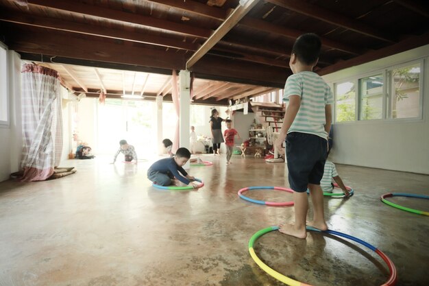 家で一緒に遊んでいる小さなアジアの子供たちのグループ、ホームスクールの概念の背景