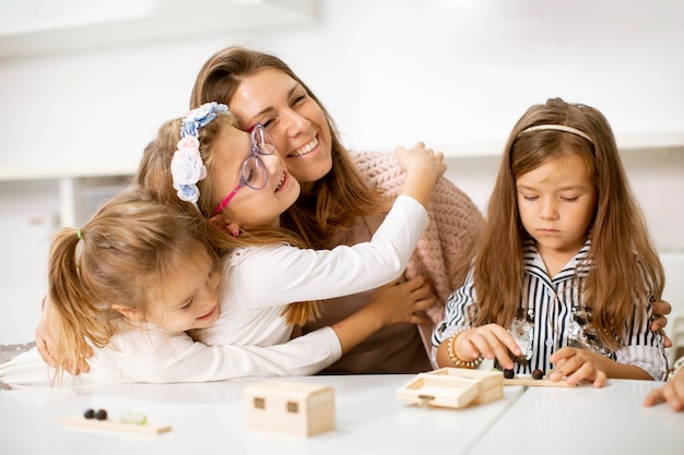 Group of little kids playing with preschool wooden educational toys with kindergarden teacher