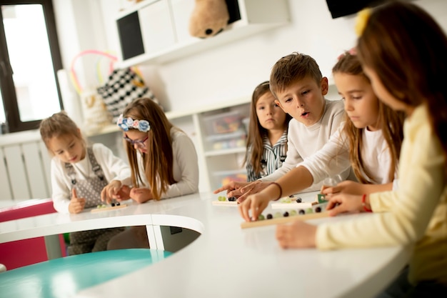 Group of little kids playing with preschool wooden educational toys