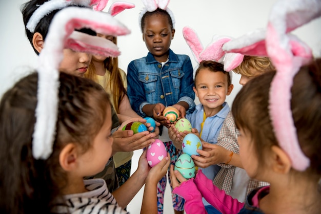 Un gruppo di bambini piccoli che mostrano le loro uova di pasqua l'un l'altro