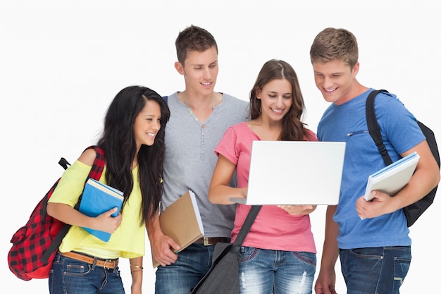 A group looking into a laptop and smiling