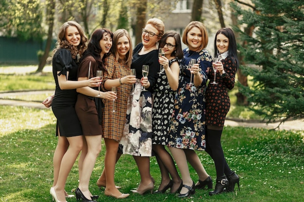 シャンパンの陽気な瞬間の幸せを祝い、乾杯する豪華でエレガントな女性のグループ