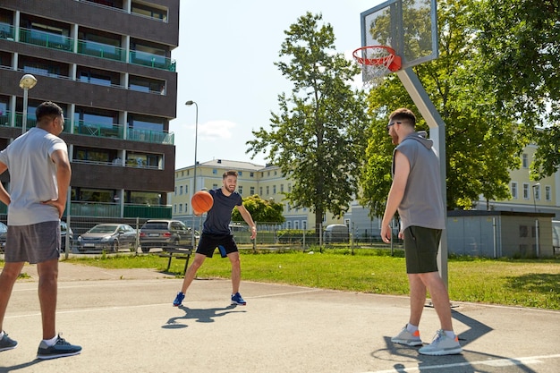 group of male friends playing street basketball