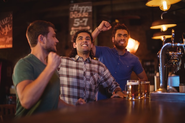 Group of male friends watching football match