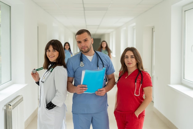 Photo group of medical team studetns or young doctors in uniform in college hallway