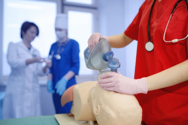 Gruppo di operatori sanitari. il concetto della pratica della respirazione artificiale da parte di un giovane medico. consegna forzata di ossigeno ai polmoni del paziente da parte di un'infermiera. sfondo cpr