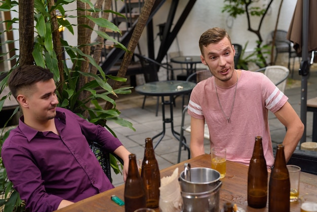 Group of men outdoors sitting and drinking beer