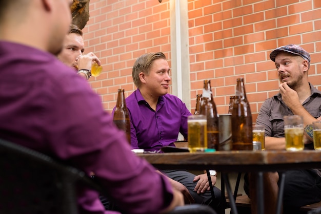 Group of men outdoors sitting and drinking beer