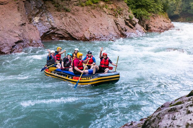 Photo group of men and women are rafting on the river, extreme and fun sport