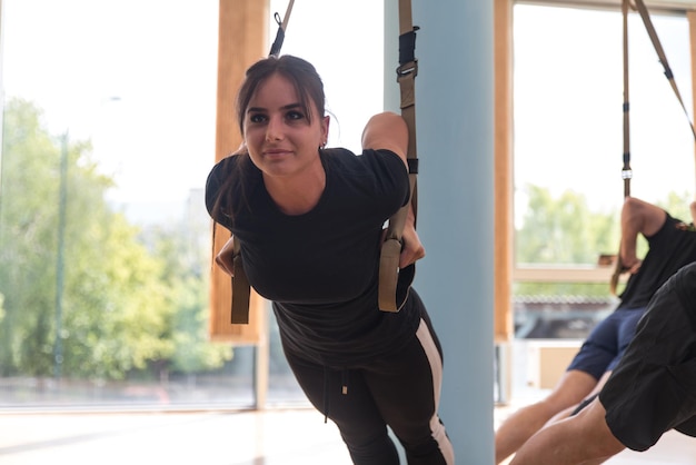 Group of Men and Women Exercising With Suspension Training Trx