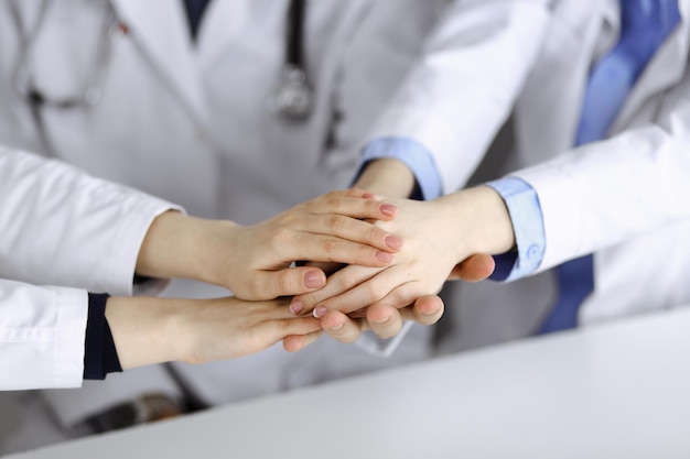 Group of modern doctors joining hands as a circle and ready to\
help patients. teamwork in medicine during coronavirus pandemic.\
covid 2019.