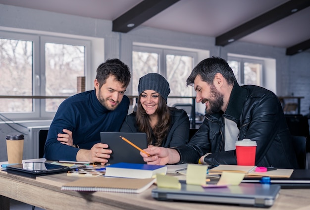 Group of modern people discussing work on tablet in the office Working environment