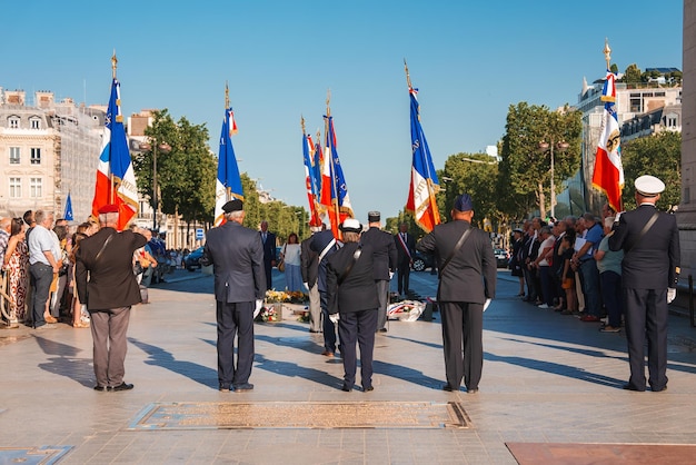 Group at monument with flags in sunny paris