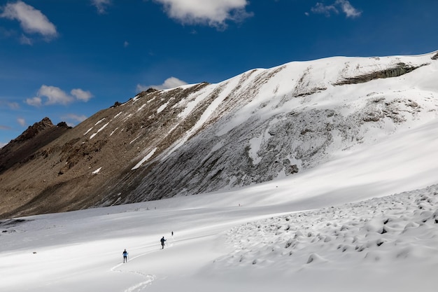 Группа альпинистов, идущих по местности горы Кайлаш, команда из нескольких человек