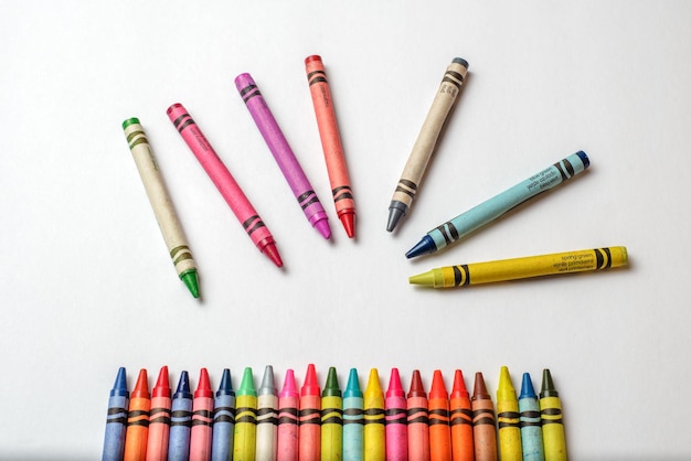 Group multicolored crayons messy and isolated on white background