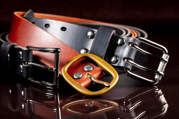 A group of multicolored leather belts on a black background