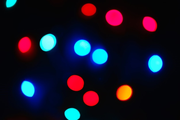 Group of multicolored lights defocus, festive bokeh on a dark background, abstract colored backdrop