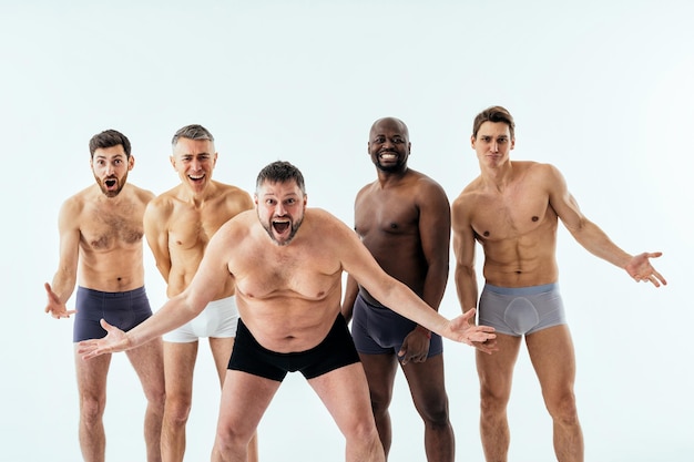 Gruppo di uomini multietnici che posano per un set di bellezza positivo per il corpo in edizione maschile. ragazzi a torso nudo con età diverse e un corpo che indossa biancheria intima da boxer