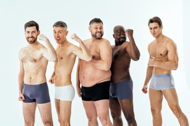 Group of multiethnic men posing for a male edition body positive beauty set. Shirtless guys with different age, and body wearing boxers underwear