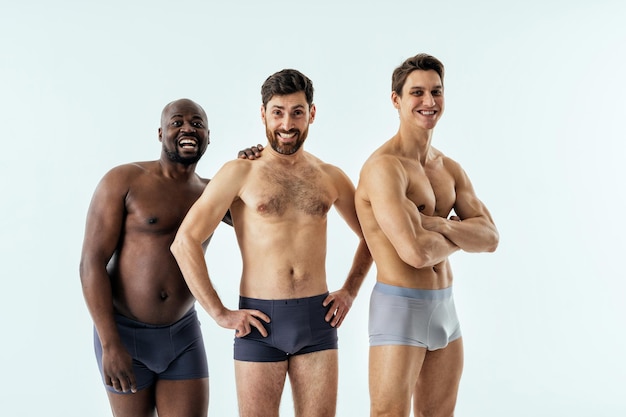 Group of multiethnic men posing for a male edition body positive beauty set. Shirtless guys with different age, and body wearing boxers underwear