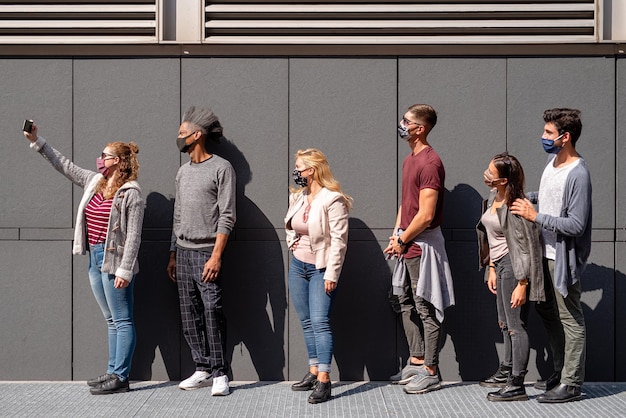 Foto gruppo di studenti multietnici che posano per un selfie con distanziamento sociale e maschera protettiva nuovo concetto normale durante l'epidemia di coronavirus